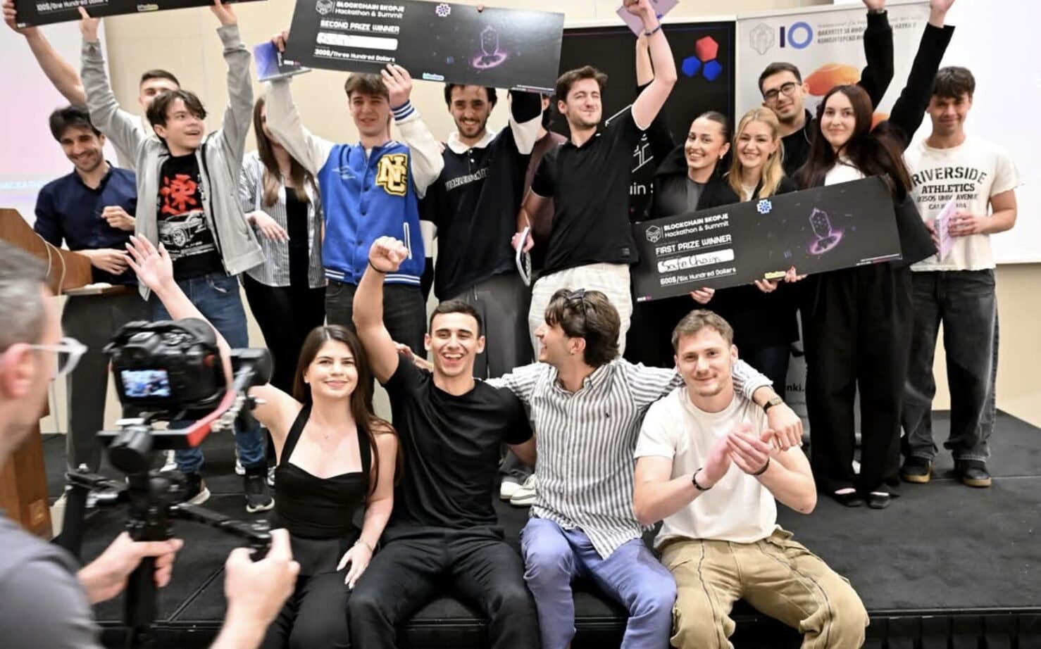 Winning teams on stage holding their prize boards.